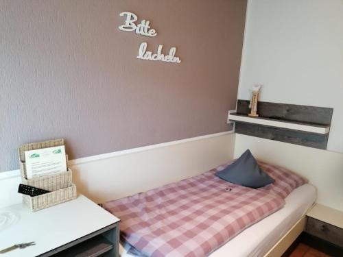 ein kleines Bett in einem Zimmer mit einem Schild an der Wand in der Unterkunft Hotel Haus Hildegard - Garni 3 Sterne superior in Niederkrüchten