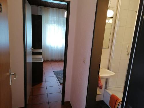 ein Bad mit einer Tür, die zu einem Zimmer mit einer Badewanne führt in der Unterkunft Hotel Haus Hildegard - Garni 3 Sterne superior in Niederkrüchten