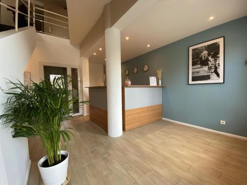 a living room with a potted plant and a column at Hôtel La Rotonde in La Croix-Valmer