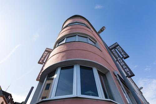 un grand bâtiment rouge avec une fenêtre ronde dans l'établissement Hotel Martin, à Limburg an der Lahn
