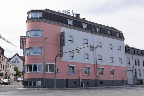 un bâtiment rouge et blanc au coin d'une rue dans l'établissement Hotel Martin, à Limburg an der Lahn