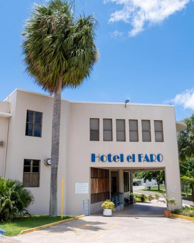 a hotel at fapa with a palm tree in front at Parador El Faro in Aguadilla