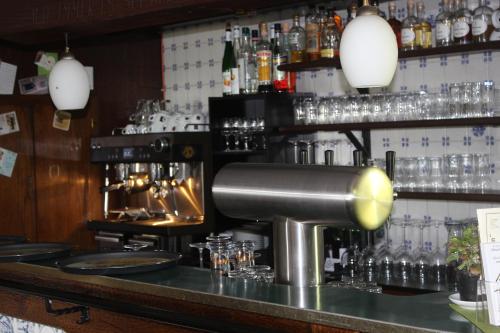 un bar con una batidora y vasos en un mostrador en Landgasthof Zum Häuschen en Rösrath