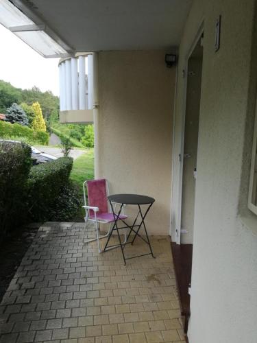 une table et deux chaises assises sur une terrasse dans l'établissement Studio pour cure Eugénie les Bains, à Eugénie-les-Bains