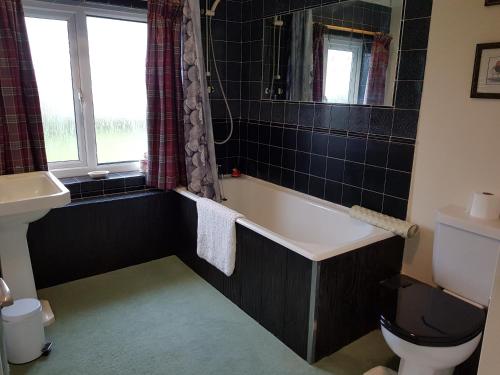 a bathroom with a bath tub and a sink at House On The Hill in Little Massingham