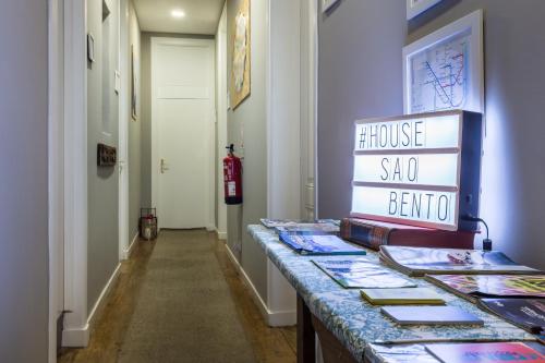 a hallway with a table with books on it at House Sao Bento in Lisbon