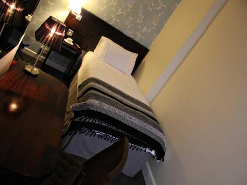 a bedroom with a bed with a wooden headboard at Hotel Belmonte in Norwich
