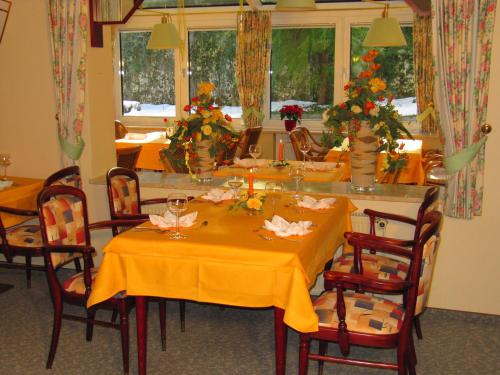 a dining room with a table with a yellow table cloth at Hotel Pension Marie-Luise, Hotel garni in Bad Bevensen