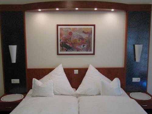 a bedroom with a bed with white pillows at Hotel Pension Marie-Luise, Hotel garni in Bad Bevensen