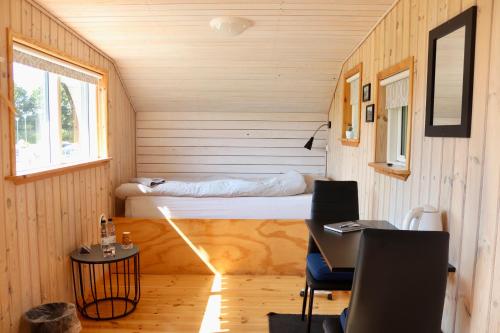 a small room with a bed in a tiny house at Plexus Hytterne in Holstebro