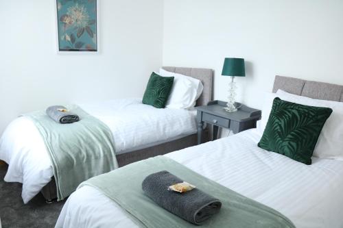 a hotel room with two beds with towels on them at Ideal Lodgings in Bury - Whitefield in Bury