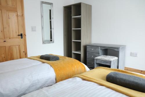 een slaapkamer met 2 bedden en een dressoir bij Ideal Lodgings in Bury - Whitefield in Bury