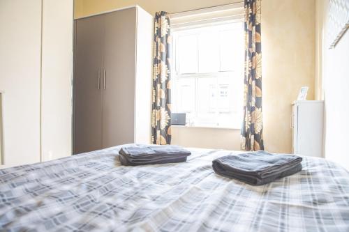 two pillows on a bed in a room with a window at Ibstock Self Catered Apartment in Ibstock