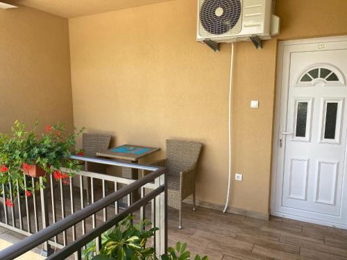 balcón con mesa, sillas y puerta blanca en Apartments Boss en Budva