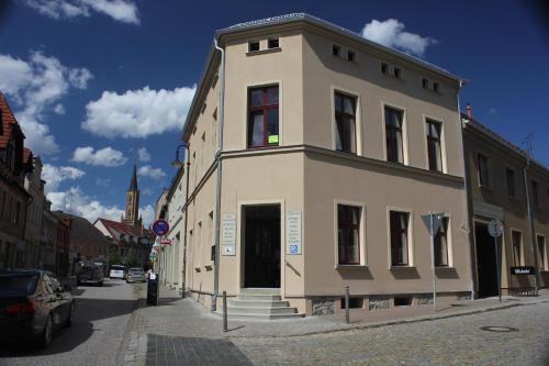 a white building on the side of a street at Gästehaus INNFernow in Fürstenberg-Havel