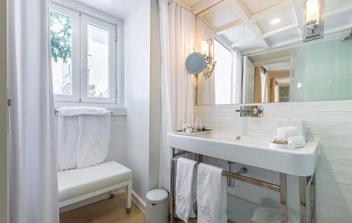 ein weißes Badezimmer mit einem Waschbecken und einem Spiegel in der Unterkunft Santiago de Alfama - Boutique Hotel in Lissabon