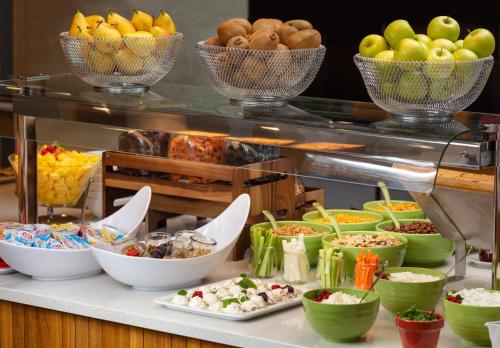 a buffet with bowls of different types of food at Holiday Inn Gdansk - City Centre by IHG in Gdańsk