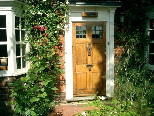 a wooden door of a house with a sign on it at Iolanthe in London