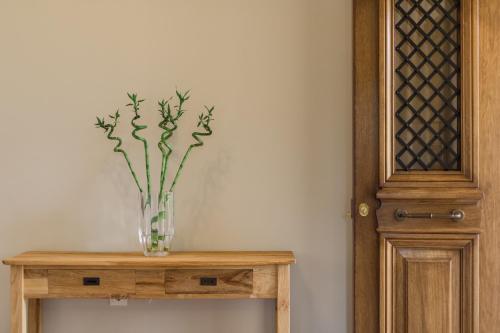 a vase of flowers sitting on a wooden table at Citrus House in Razáta