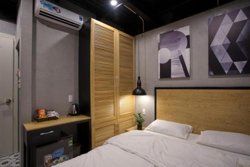 a bedroom with a bed and a wooden headboard at THE NEST QUANG BINH in Dong Hoi