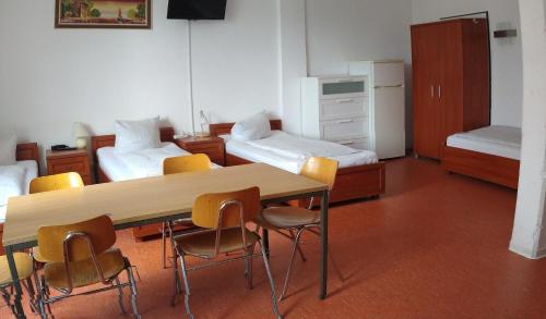una habitación con mesa y sillas y un dormitorio en Hostel am Kurtti en Berlín
