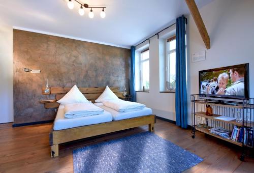 a bedroom with a bed and a tv on a wall at Kanal 33 in Schafstedt