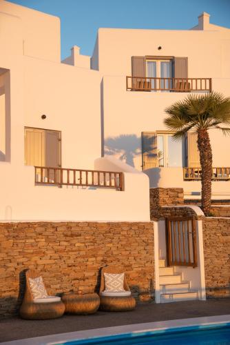 a building with a palm tree next to a swimming pool at Avanti in Ios Chora