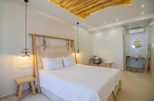 a bedroom with a large white bed and a ceiling at Avanti in Ios Chora