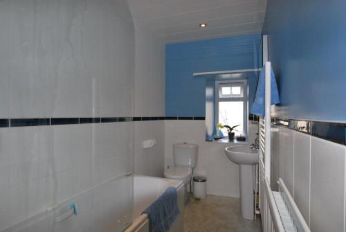 a bathroom with a tub and a toilet and a sink at Kentwood Guest House in Arnside