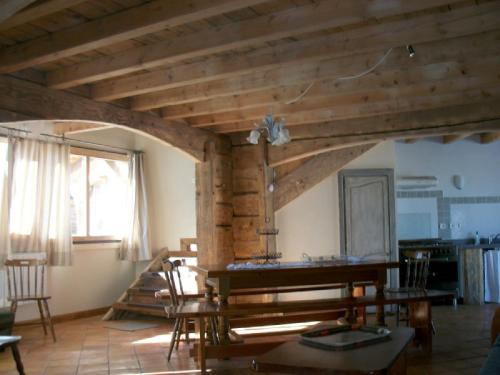 a living room with wooden ceilings and a table and chairs at Ker Cambre in Saint-Pierre-dels-Forcats