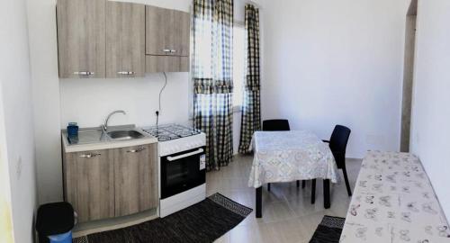 a kitchen with a table and a sink and a stove at FIORI E COLORI in Mazara del Vallo