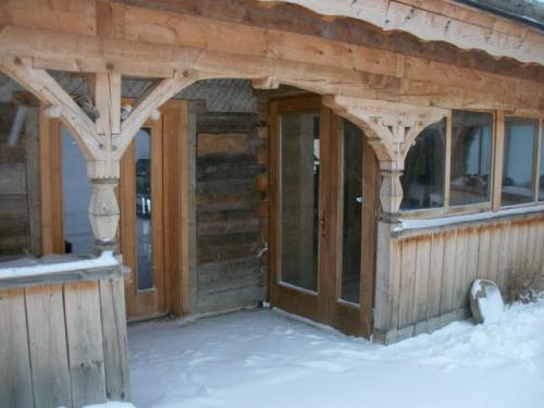 a wooden cabin with a door in the snow at Ker Peric in Saint-Pierre-dels-Forcats