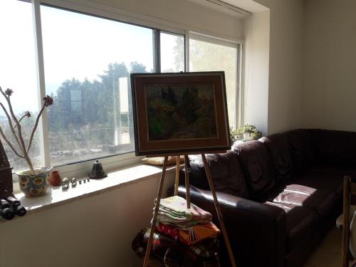a television on a stand in a living room with a couch at Oren's place - perfect for families & friend's in Kefar Weradim