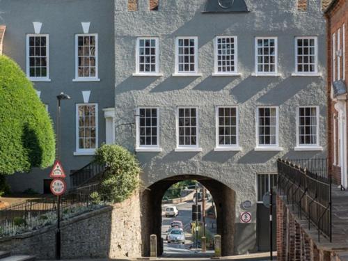 a stone building with an archway in front of a street at The Cliffe at Dinham in Ludlow