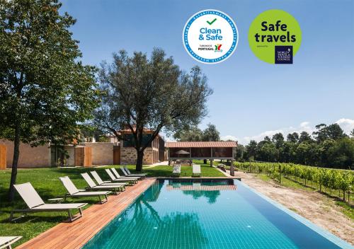 a pool with lounge chairs and a sign that says gate travels at Torre de Gomariz Wine & Spa Hotel in Braga