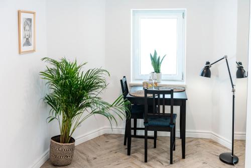 a dining room table with chairs and a plant at BOHO HOUSE in Ustrzyki Dolne