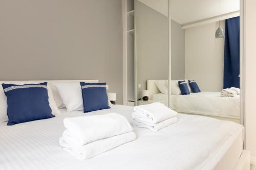 1 Schlafzimmer mit 2 Betten mit blauen und weißen Kissen in der Unterkunft Wilanów Gardens with Balcony in Warschau