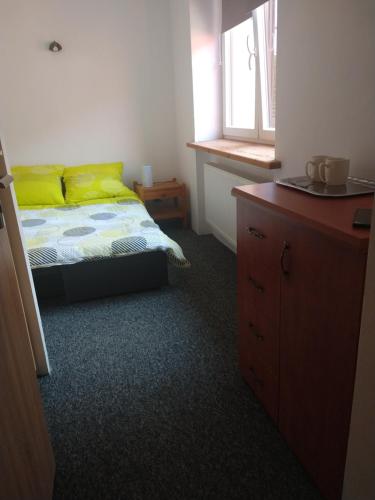 een slaapkamer met een bed met gele kussens en een dressoir bij Villa Hillas in Reda