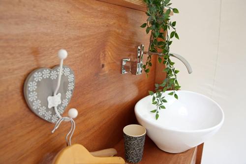 ein Badezimmer mit einer weißen Schüssel und einem Waschbecken in der Unterkunft Coeur de bull' in Cahuzac-sur-Vère