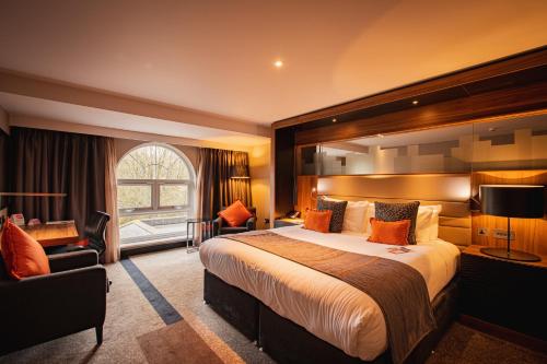 a hotel room with a large bed and a window at Crowne Plaza Gerrards Cross by IHG in Beaconsfield
