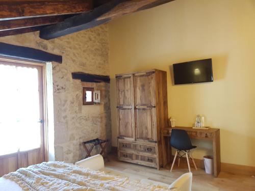 a bedroom with a bed and a tv on the wall at Posada Condado de la Mota in Mogro