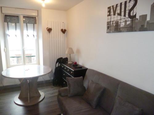 a living room with a couch and a table at Résidence les Capucines in Le Mont-Dore