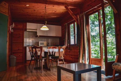 une cuisine et une salle à manger avec une table et des chaises dans l'établissement Chalets & Camping Villa Mayari, à Escosse