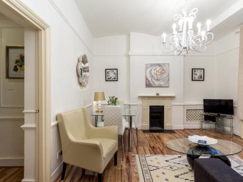a living room with a fireplace and a chandelier at Comfortable One Bed in Central in London