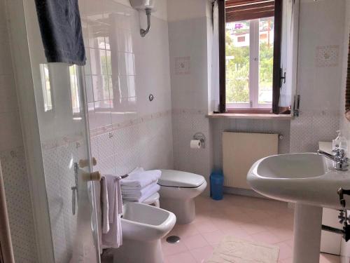 a white bathroom with a toilet and a sink at Villa Catenacci Anacapri in Anacapri