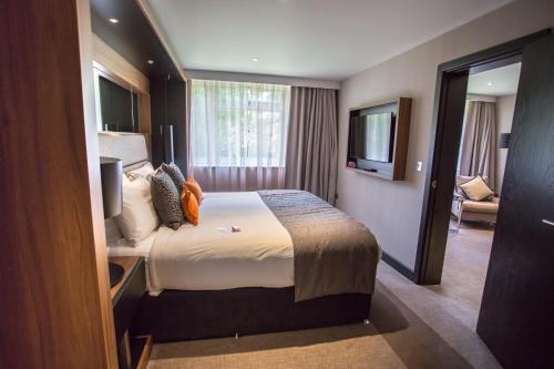 a hotel room with a bed and a television at Crowne Plaza Gerrards Cross by IHG in Beaconsfield