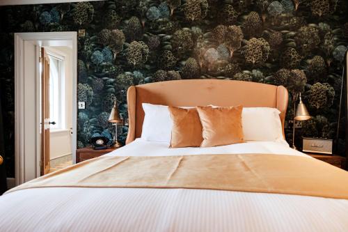 a bedroom with a bed and a wall with plants at Bear Of Burton in Christchurch
