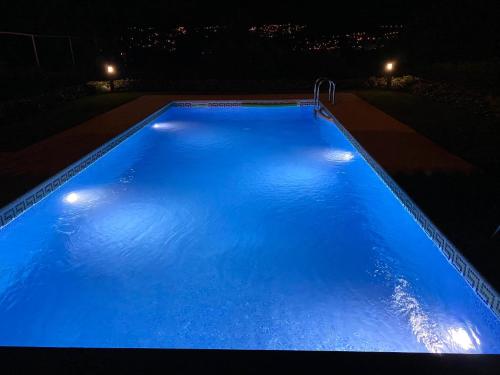 a large blue swimming pool at night with lights at Playa America! in Nigrán