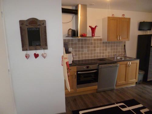 a kitchen with a figurine of a woman on the wall at Résidence les Capucines in Le Mont-Dore