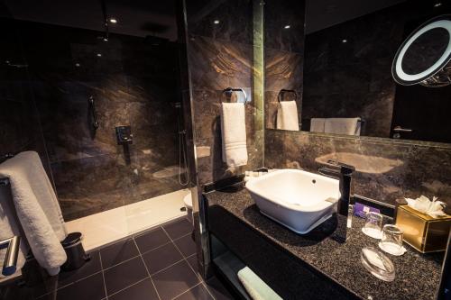 a bathroom with a sink and a shower at Crowne Plaza Gerrards Cross by IHG in Beaconsfield